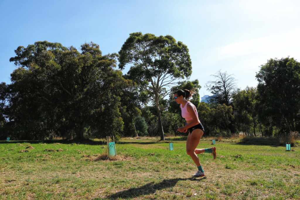 Kate running up a hill during a workout in Australia